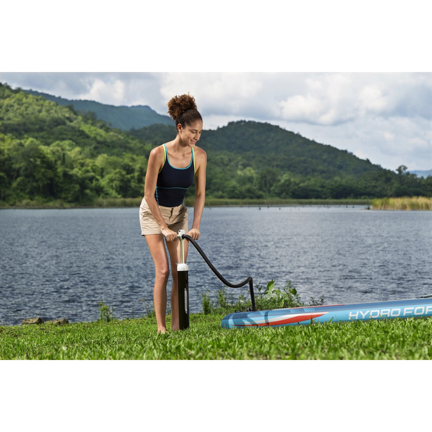 Frau pumpt Bestway SUP Board Oceana mit Pumpe auf. Allround Stand Up Paddle Board Set.