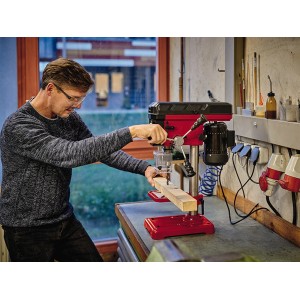 Einhell TC-BD 450 Säulenbohrmaschine beim Bohren von Holz, rot/schwarz.