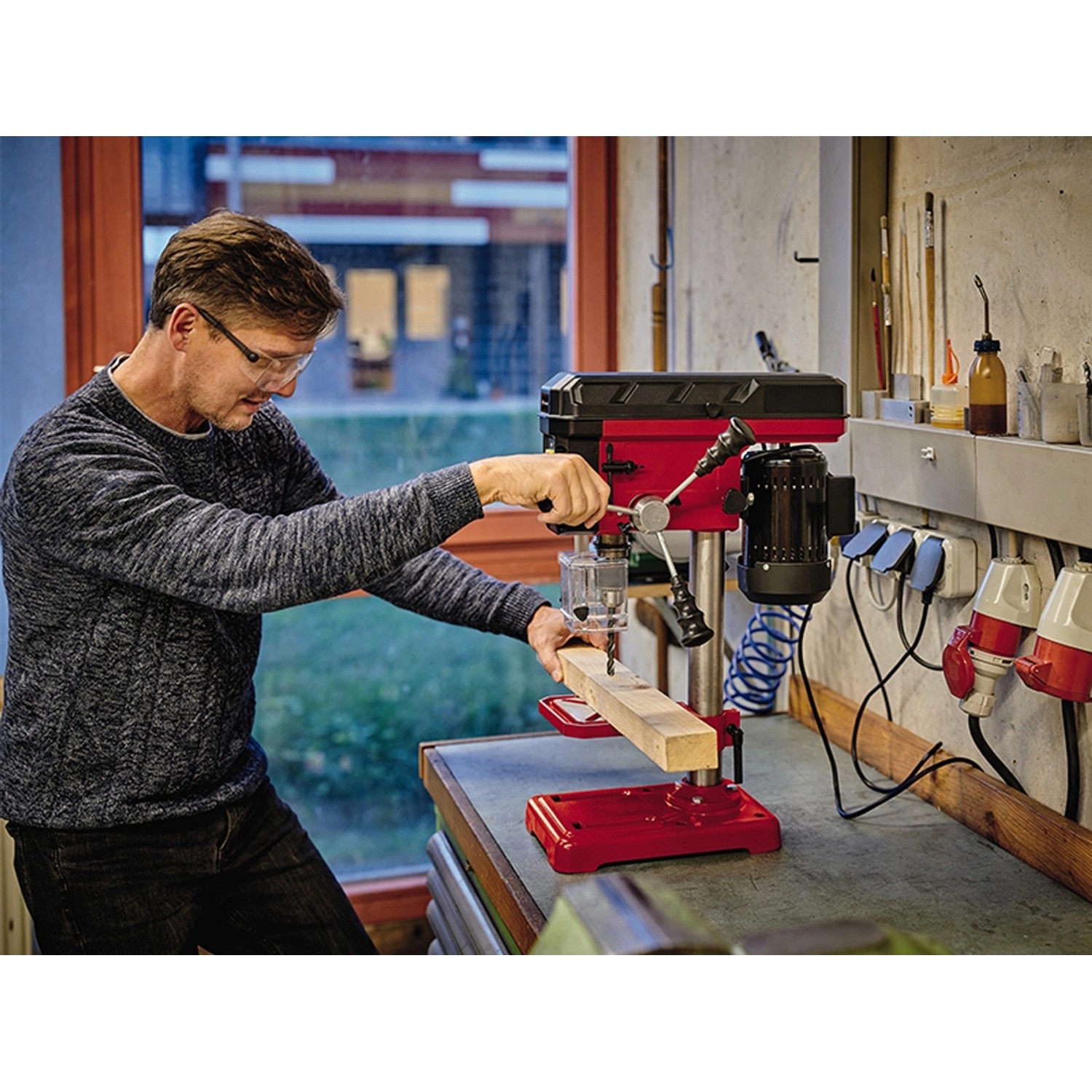 Einhell TC-BD 450 Säulenbohrmaschine beim Bohren von Holz, rot/schwarz.