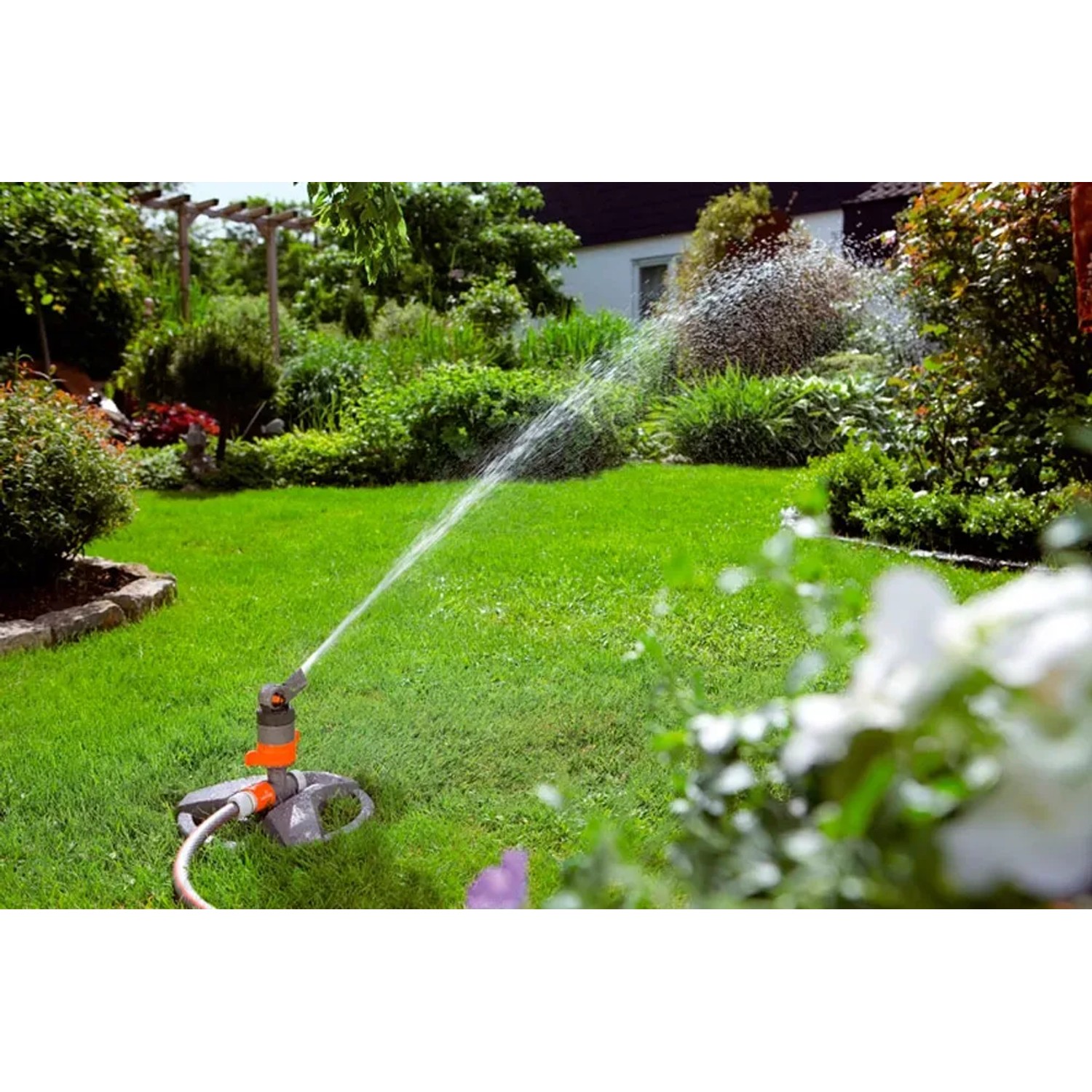 Gardena Comfort Turbinenregner mit Schlitten bewässert Rasenfläche im Garten.