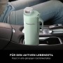 Mintfarbene Ninja Thirsti Trinkflasche (530ml) im Getränkehalter eines Autos.