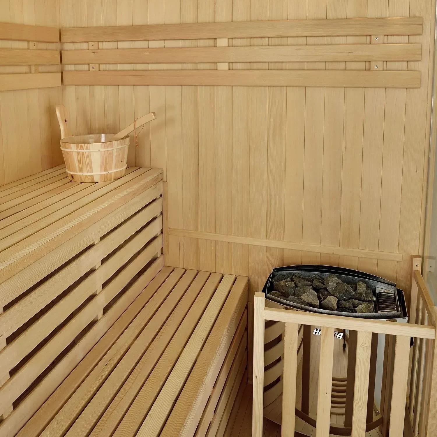 Innenansicht der Artsauna Espoo150 Premium Sauna mit Bänken, Ofen und Zubehör.
