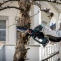 Mann schneidet Ast mit Metabo Akku-Gehölzsäge MS 18 LTX 15. Inkl. Akku, Ladegerät und Tasche.