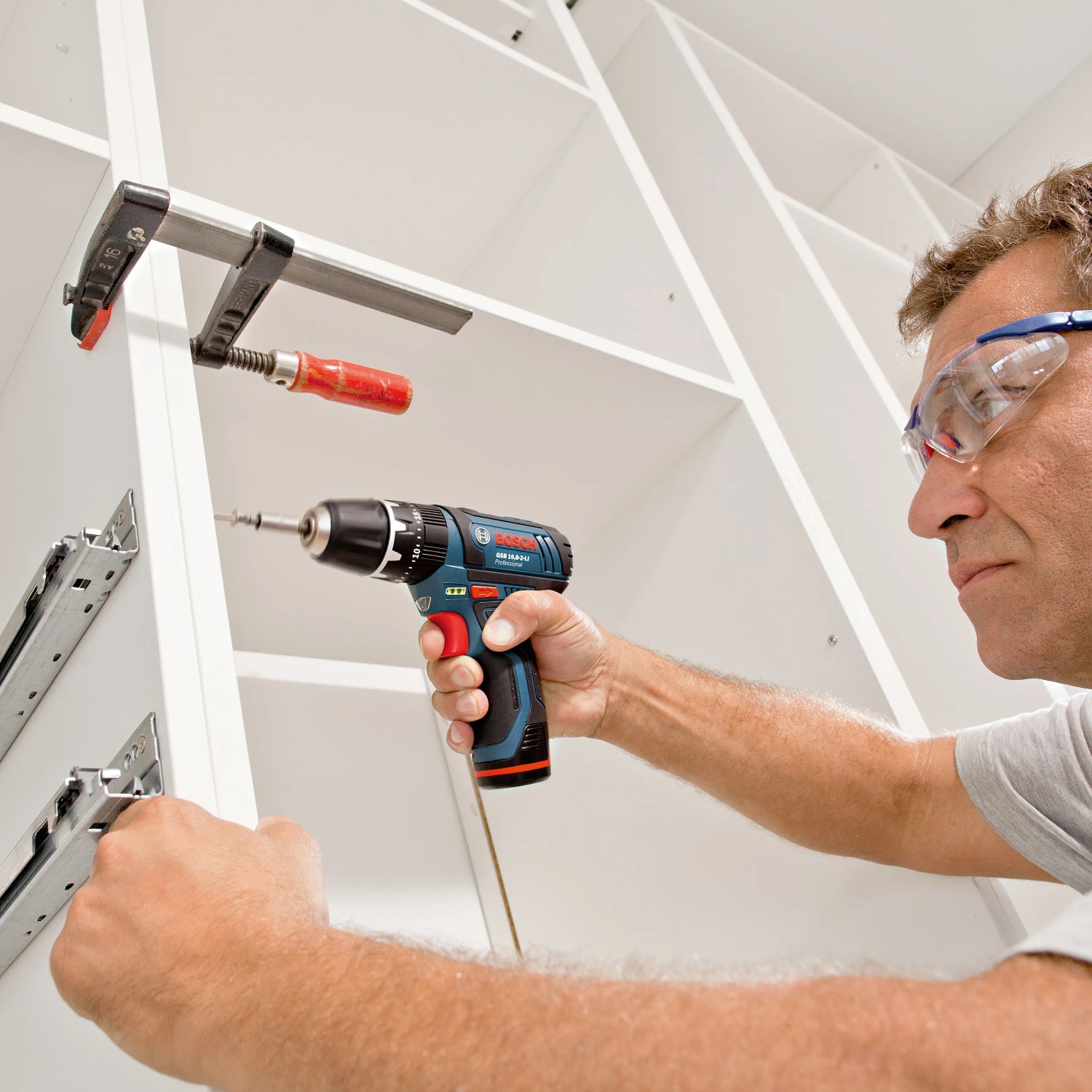 Mann schraubt mit Bosch Professional Akku-Bohrschrauber GSR 12V-15 im Koffer.