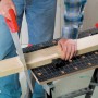 Werk- und Spanntisch im Einsatz: Holzbalken wird mit Säge bearbeitet.