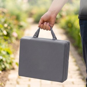 Person trägt graue, faltbare Garten Kniematte mit Griffen im Garten. Stoßdämpfender Knieschutz für Garten & Werkstatt.