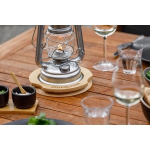 Feuerhand Sturmlaterne Baby Special auf Bambus Untersetzer auf Holztisch.