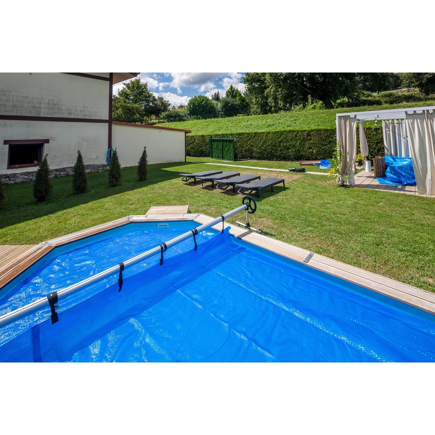 Gre Planenaufroller aus Aluminium für Einbaubecken mit blauer Poolabdeckung.