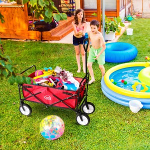 Roter, faltbarer Bollerwagen AB100 von Axi, beladen mit Spielsachen im Garten.