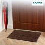 Braune Karat Schmutzfangmatte Brasil 90x150 cm vor einer Holztür. Muster mit dunklen Schnörkeln.