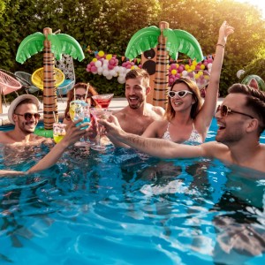 Aufblasbare Dekopalmen im 2er Set im Pool mit feiernden Menschen. Poolzubehör.