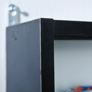 Detailaufnahme: Wandhängender Vitrinenschrank in Schwarz/Weiss mit Glastüren.