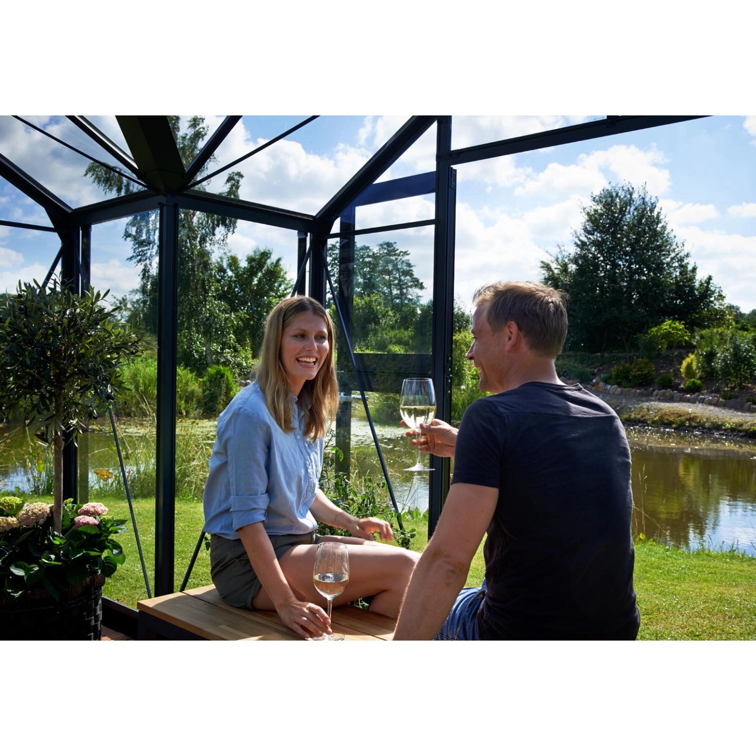 Juliana Gewächshaus Orangerie 15 in Schwarz-Anthrazit: Paar entspannt mit Wein im Gewächshaus.
