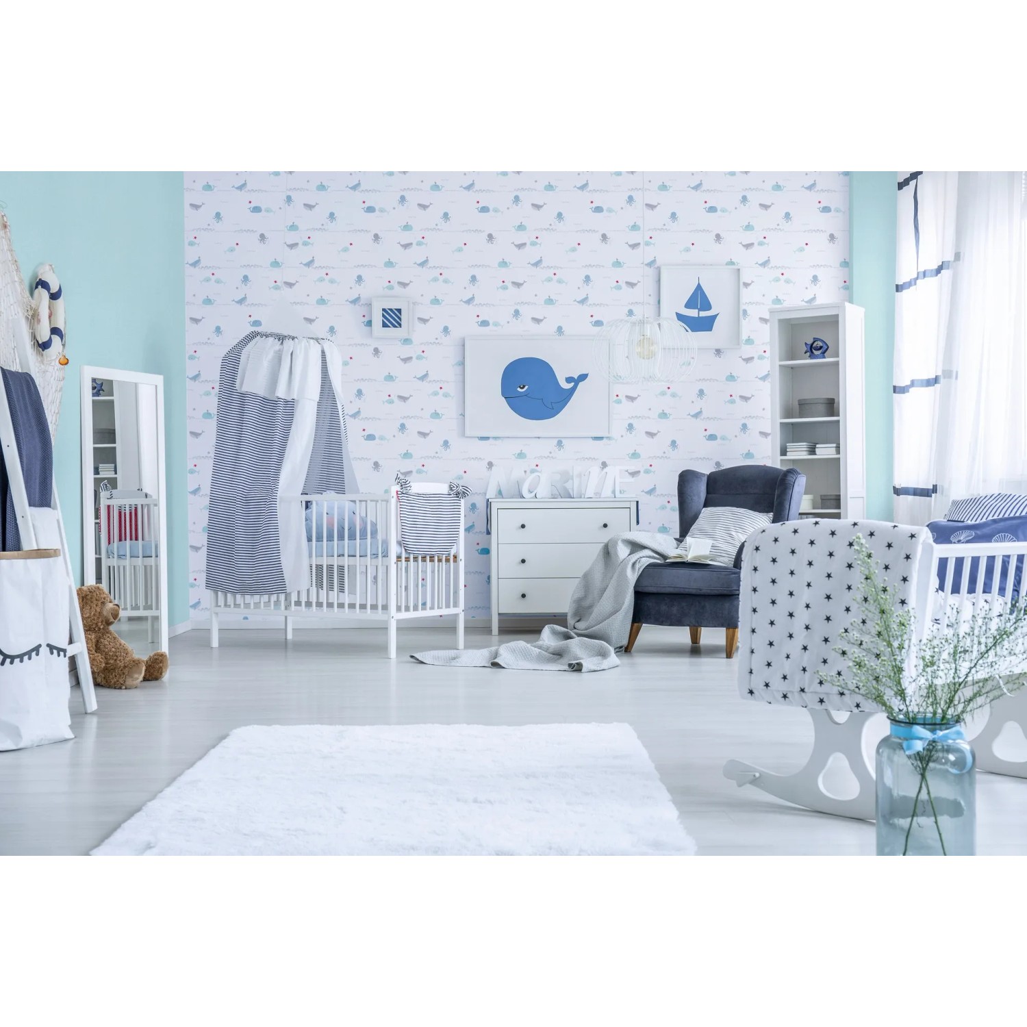Kinderzimmer mit Vliestapete mit Tieren in Blau und Grau. Dekorative Tapete mit Walen und Segelbooten.