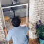 Mann montiert weiße Tesa Fliegengitter-Tür mit Alu-Rahmen im Türrahmen.