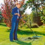 Frau rechen Rasen mit Gardena combisystem-Rasenrechen 60 cm im Garten.