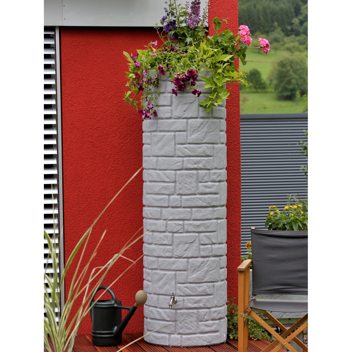 Arves Regentonne Arcado 460 l in Granit-Optik mit Bepflanzung und Wasserhahn im Garten.