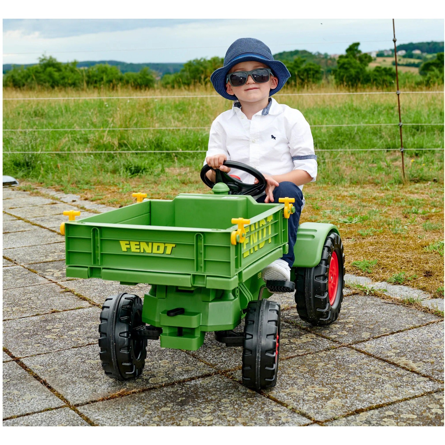 Grüner BIG Kindertraktor Fendt mit Junge und verstellbarem Sitz im Freien.