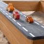 Roba Sandkasten: Detail der Holzstraße mit drei bunten Spielzeugautos. Ideal für fantasievolle Rollenspiele im Garten.