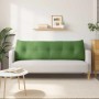 Hellgrünes Samt-Rückenkissen mit Knopfheftung auf hellem Sofa. Ergonomisches Kissen für Komfort im Wohnzimmer.