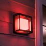 Quadratische Philips Hue Econic LED-Wandleuchte mit rotem Licht an Hauswand.
