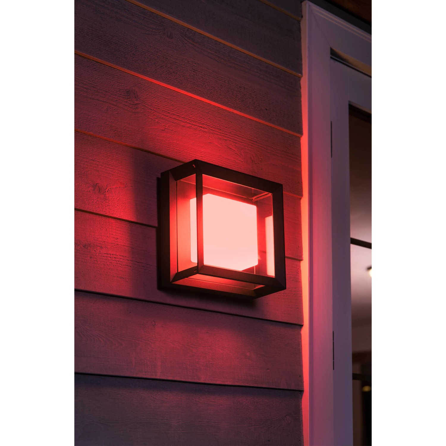 Quadratische Philips Hue Econic LED-Wandleuchte mit rotem Licht an Hauswand.
