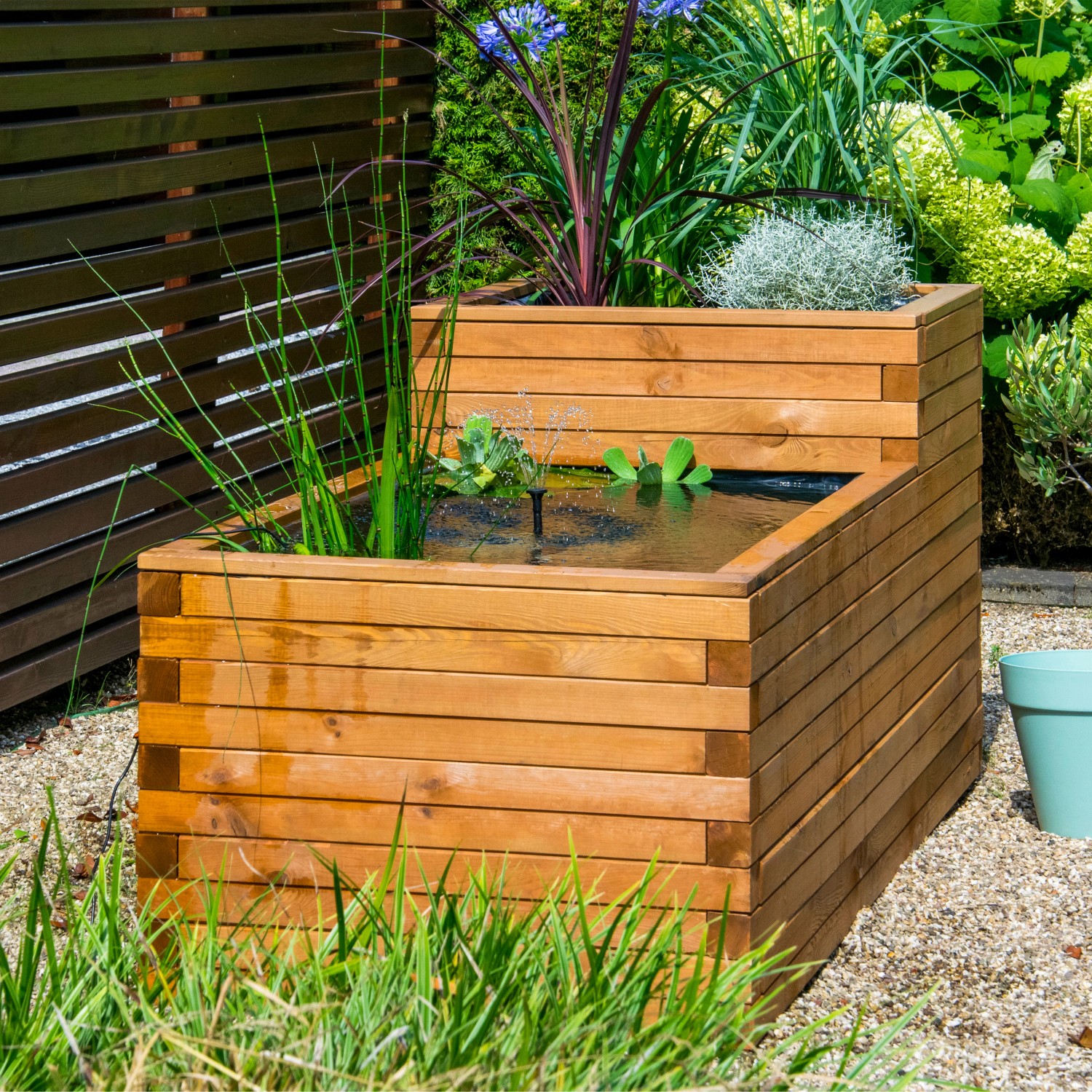 Dobar Hochteich Superb aus Kiefernholz mit Teichfolie, bepflanzt mit Wasserpflanzen und kleinem Springbrunnen.