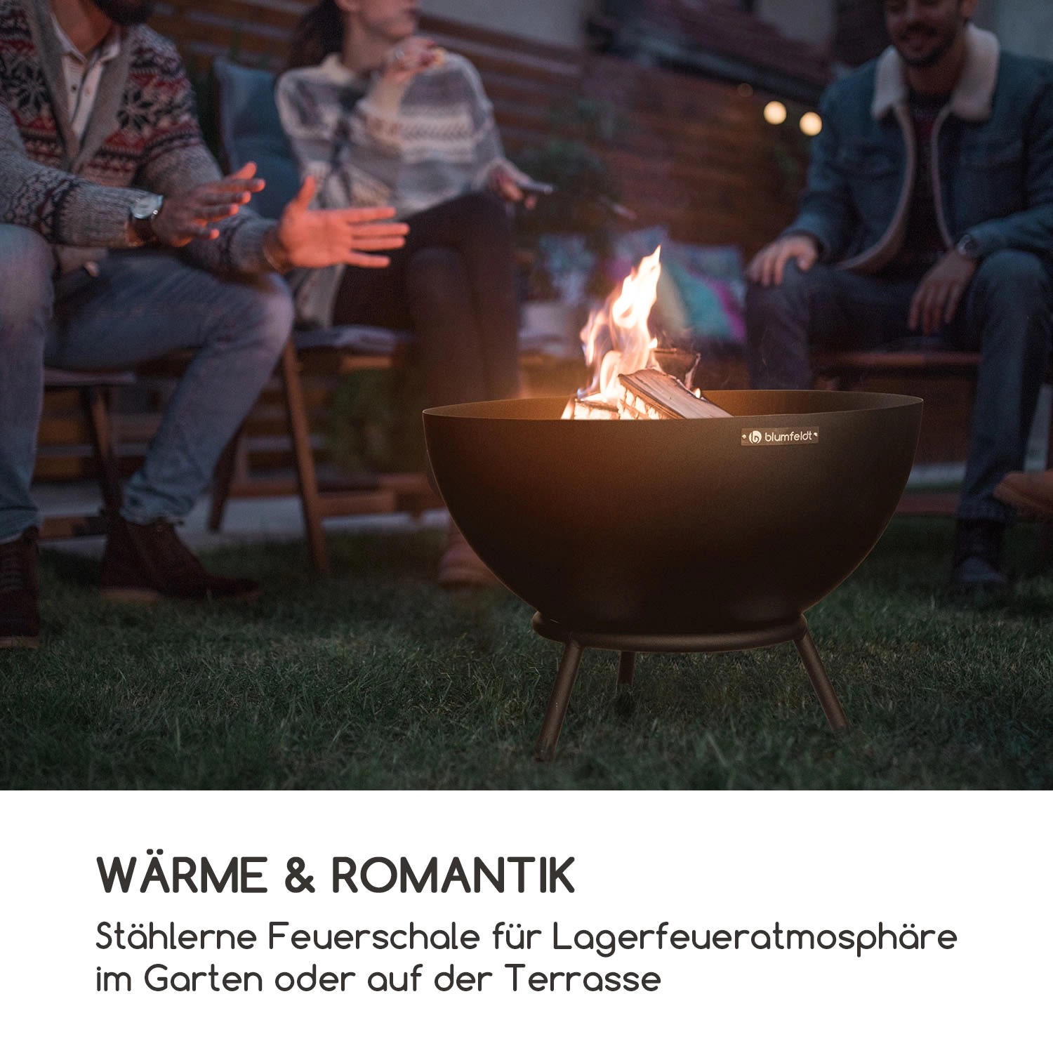 Blumfeldt Fireball Feuerschale (Ø 66cm) aus Stahl mit Feuer und Personen im Garten.