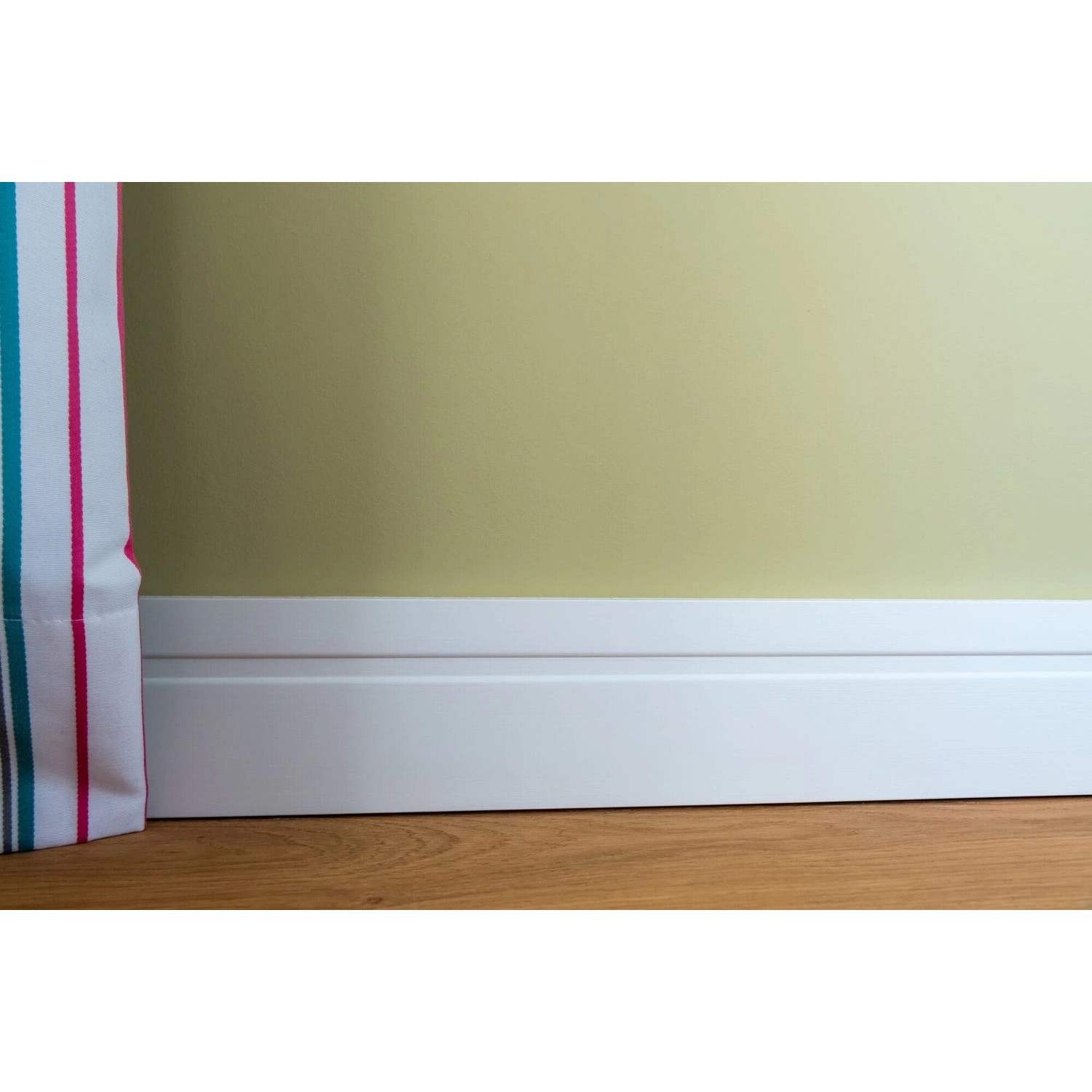 Weiße NOEL & MARQUET Sockelleiste FD11 WALLSTYL an Wand und Holzboden.