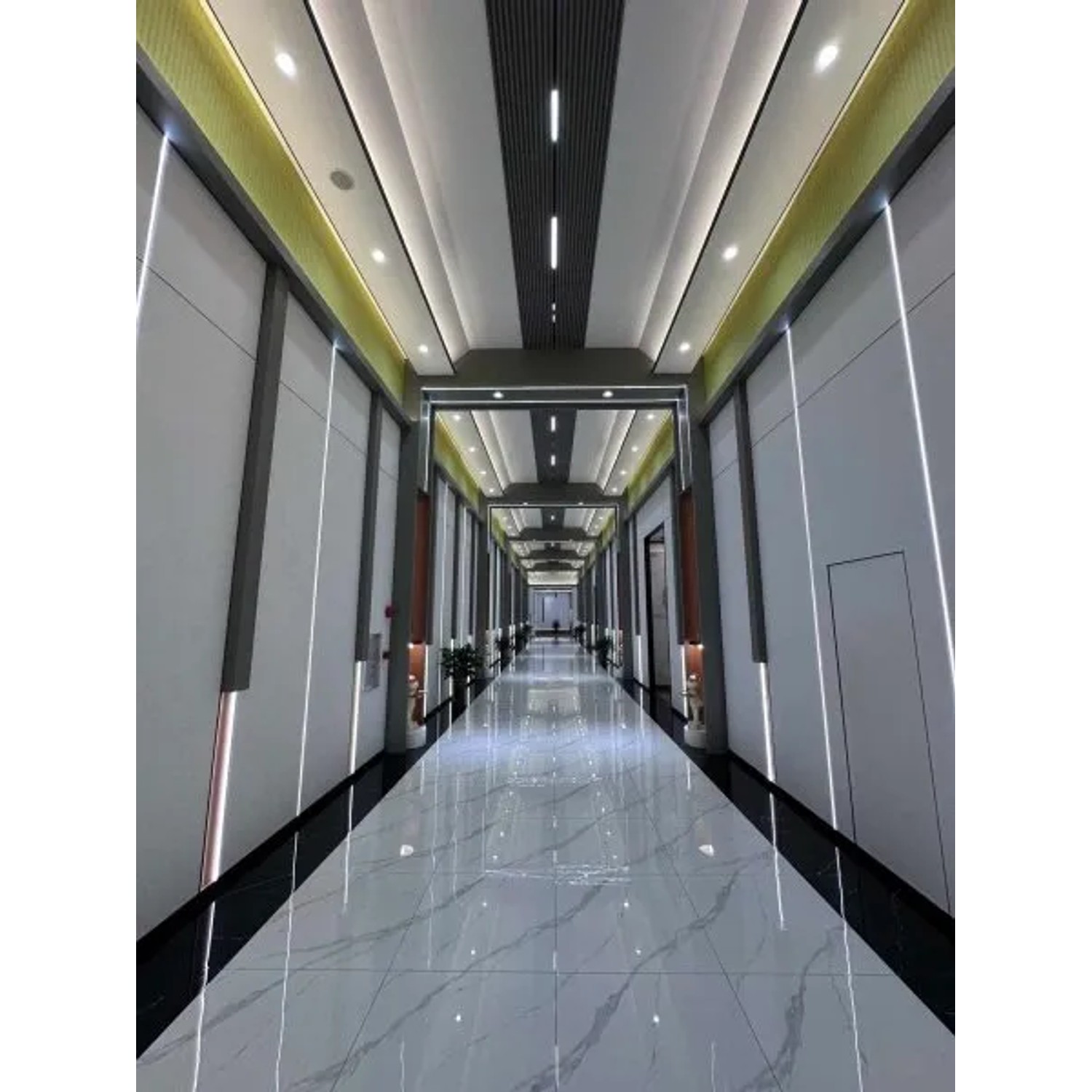 Langer Flur mit Colortree Akustikpaneelen in Schwarz und Metall an Wänden und Decke.