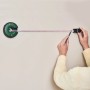Bosch Atino Linienlaser mit Maßband im Einsatz zum Ausmessen von Bohrlöchern an einer Wand.