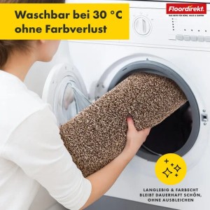 Waschbare, braune Floordirekt Badematte Nasa wird in eine Waschmaschine gelegt.