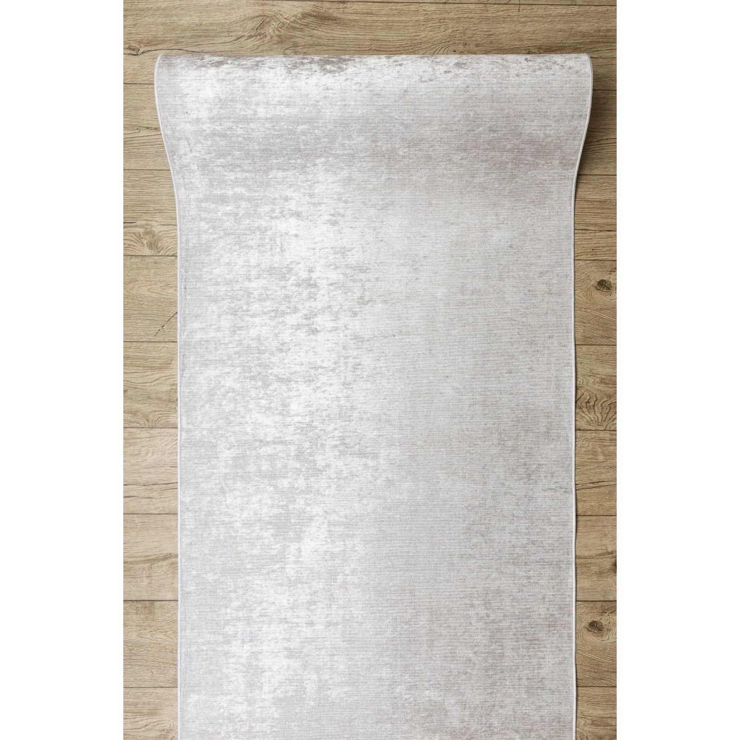Beiger Antirutsch-Läufer Lotus aus Polyester auf Holzfußboden, teilweise aufgerollt. Ideal für Flur & Küche.