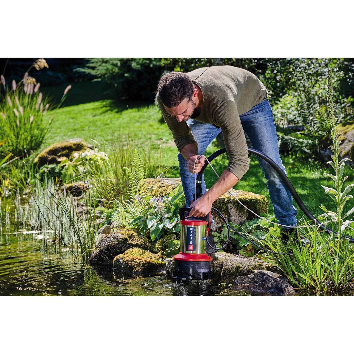 Mann bedient Einhell GE-DP 7535 N LL ECO Schmutzwasserpumpe am Teich.