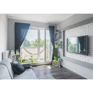 Wohnzimmer mit Gardinenstangen-Set Metall Satinoptik, schwarzen Vorhängen und Balkon mit Hängematte.
