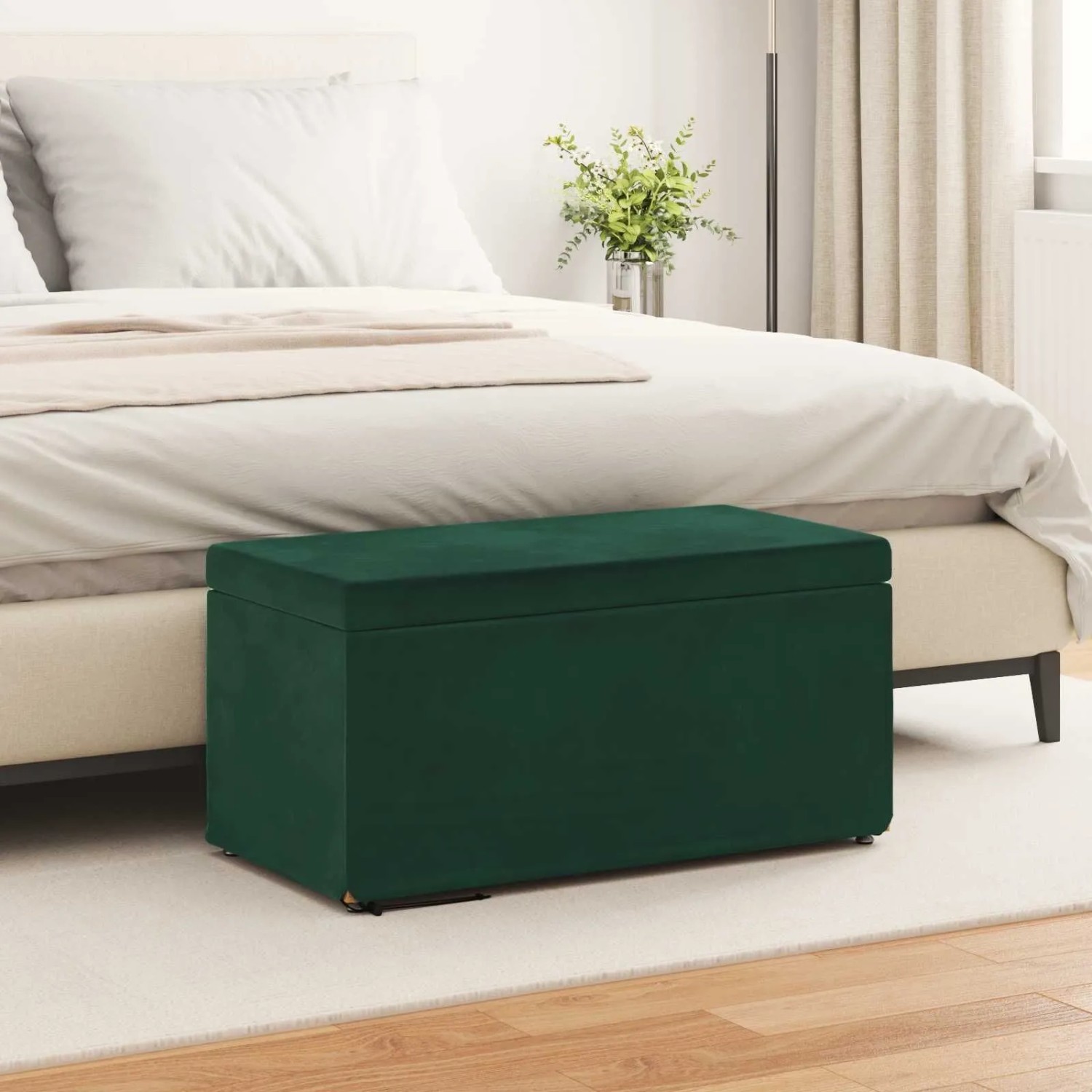 Dunkelgrüner Samt Hocker mit Stauraum, 81x41x40 cm, vor einem Bett im Schlafzimmer. Modernes Design.
