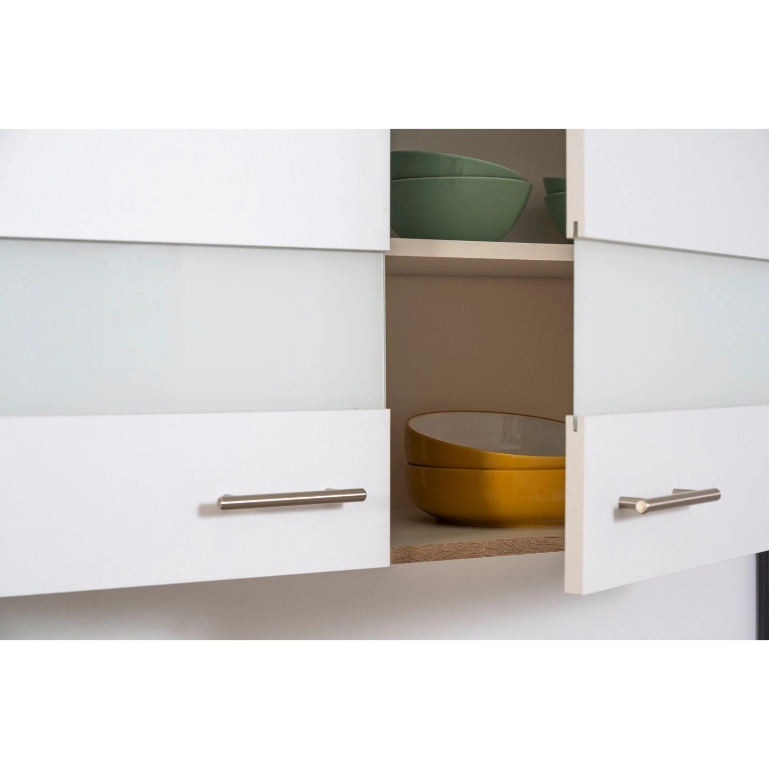 Detailaufnahme: Weiße Küchenzeile mit Glaselementen und Schränken mit Geschirr.