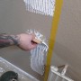 Anwendung von Soudal Fix All Floor & Wall Kleber mit Spachtel auf einer Wand.