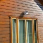 Lutec LED-Solarleuchte Zeta mit Bewegungsmelder an Holzwand montiert.