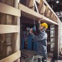 Handwerker bohrt mit dem Bosch Professional Akku-Bohrschrauber GSR 18V-55 in Holz.