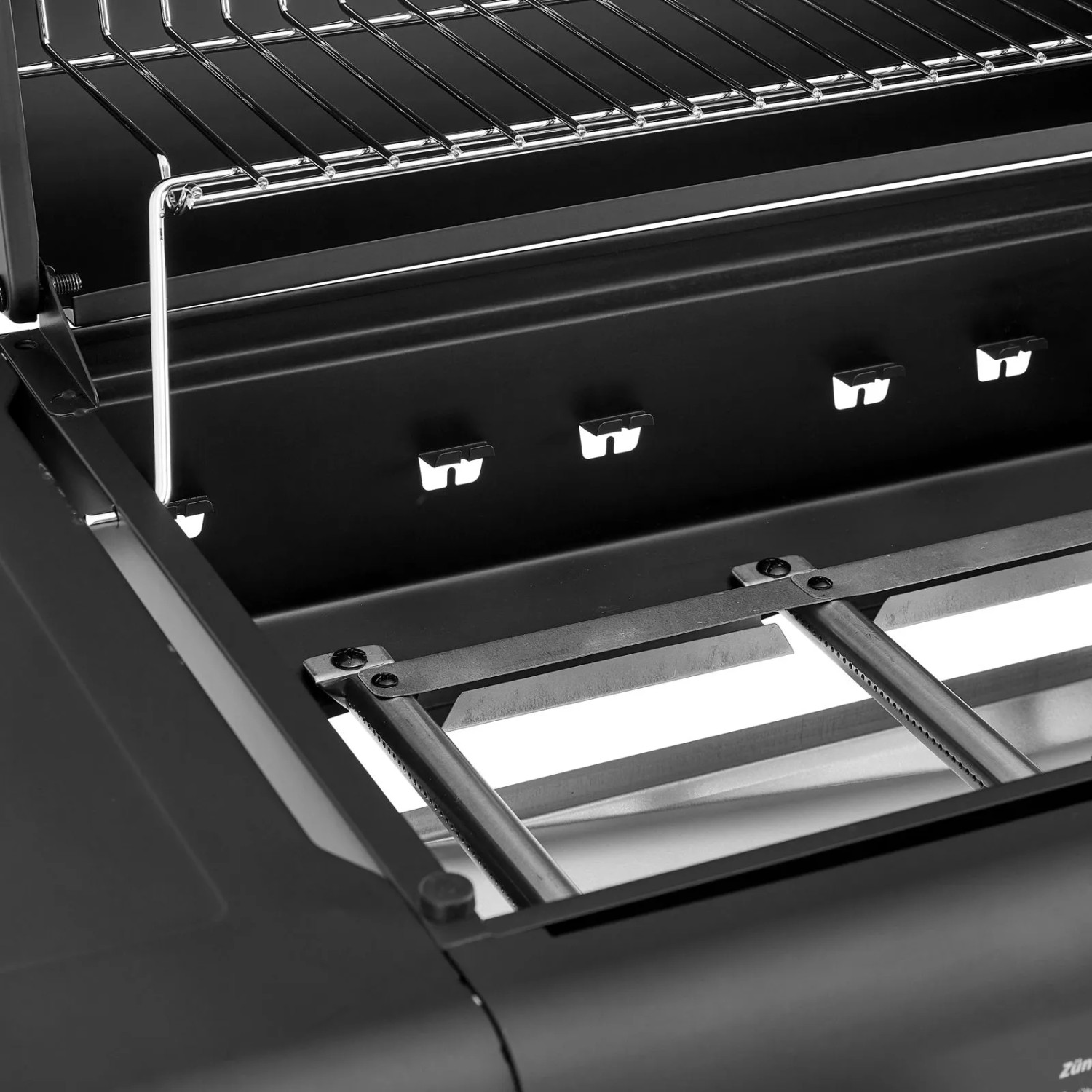 Innenansicht des schwarzen Taino Compact 3+0 Gasgrills mit Edelstahlbrennern, Grillrost und Warmhalterost.