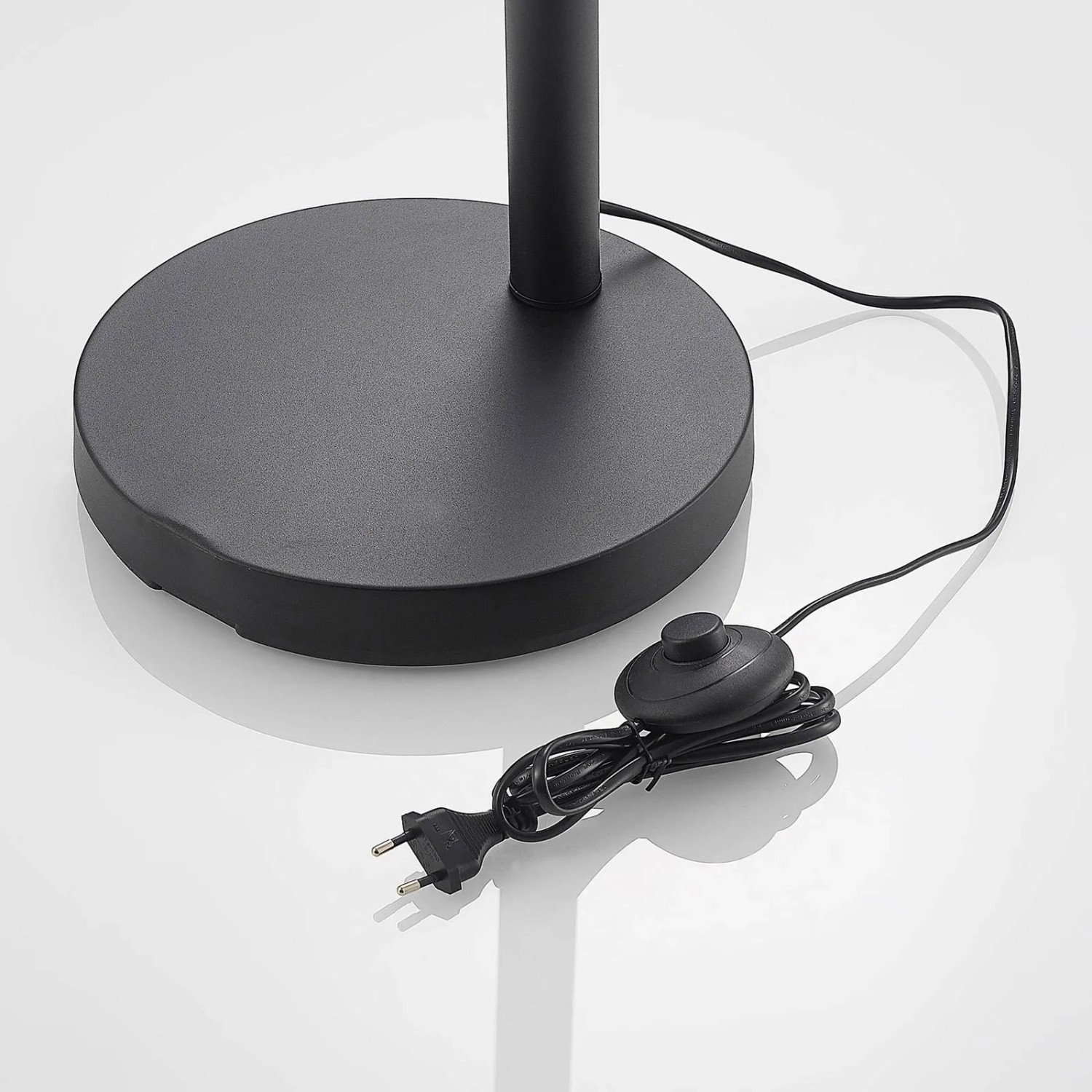 Detailaufnahme: Schwarze Lindby Bogenleuchte Abiram, Standfuß, Kabel und Fußschalter.