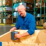 Mann tackert Holzkiste mit Novus Akku-Tacker J 214 im Lager.