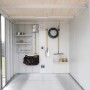 Helles Interieur des Biohort Neo Gerätehauses mit Regalen, Haken und Gartengeräten für geordneten Stauraum.