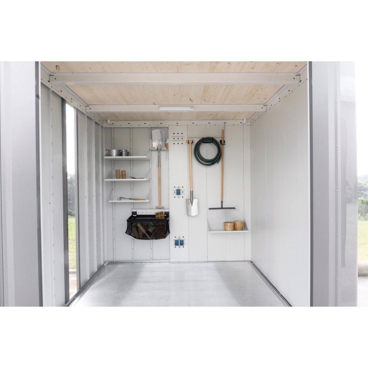 Helles Interieur des Biohort Neo Gerätehauses mit Regalen, Haken und Gartengeräten für geordneten Stauraum.