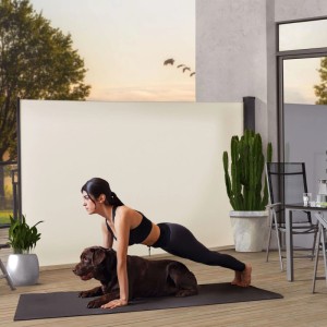 Frau macht Plank vor beiger Juskys Seitenmarkise Dubai 300x200 cm, mit Hund. Sichtschutz für Terrasse.