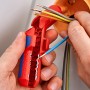 Knipex ErgoStrip Abmantelwerkzeug in Nutzung: Abisolieren eines blauen Kabels. Zange in Rot/Blau.