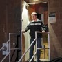 Mr. Beams LED-Außenstrahler mit Bewegungsmelder, braun, 2er-Pack, montiert an einer Wand über einer Person.