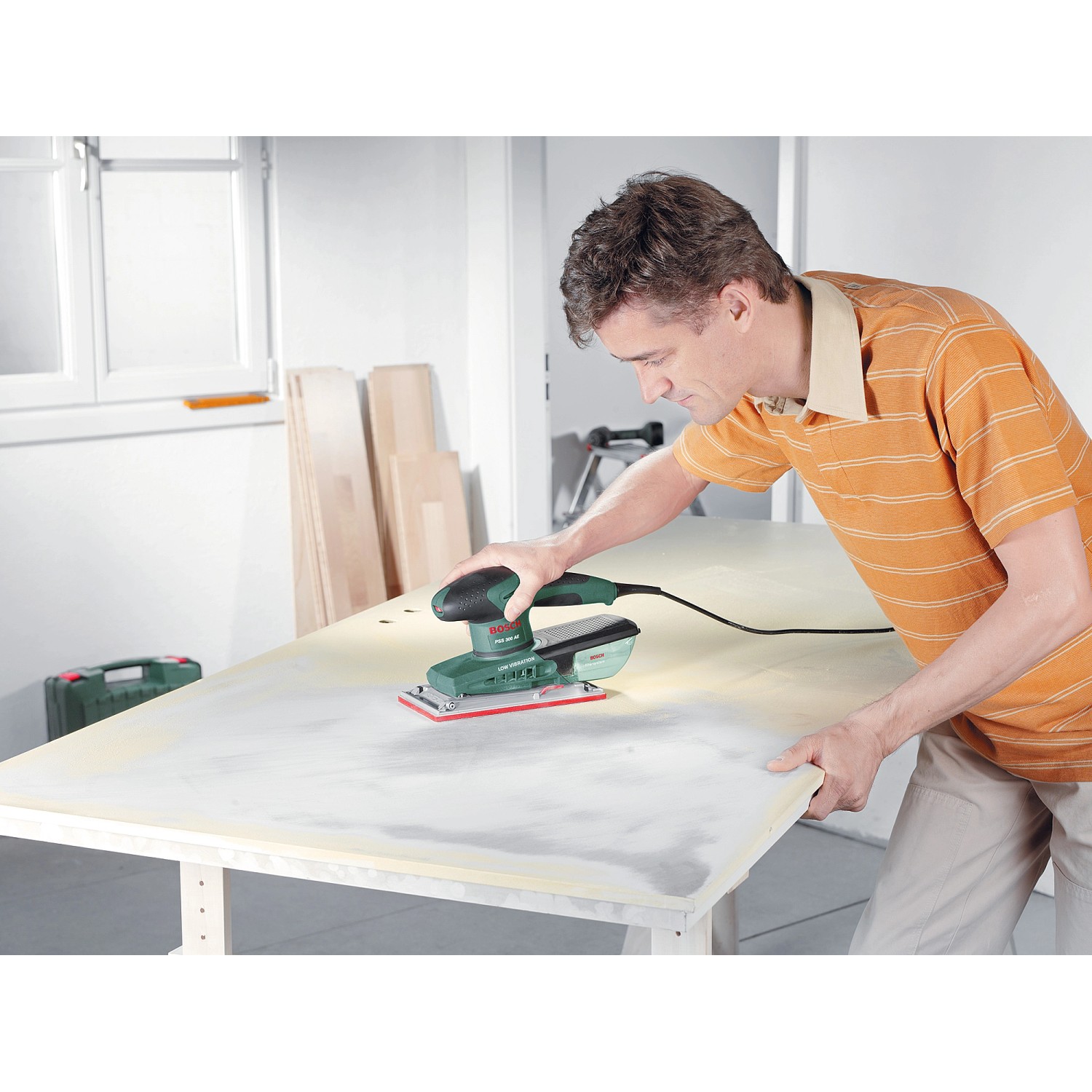 Bosch Schwingschleifer PSS 300 AE im Einsatz beim Schleifen einer Holzplatte.