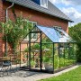Schwarzes Halls Gewächshaus Qube 610 mit Glasfront im Garten.